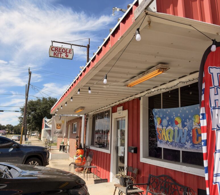Store Front of the Poolhall Cafe and Sip and Thrift. Red storefront with decorative signs.